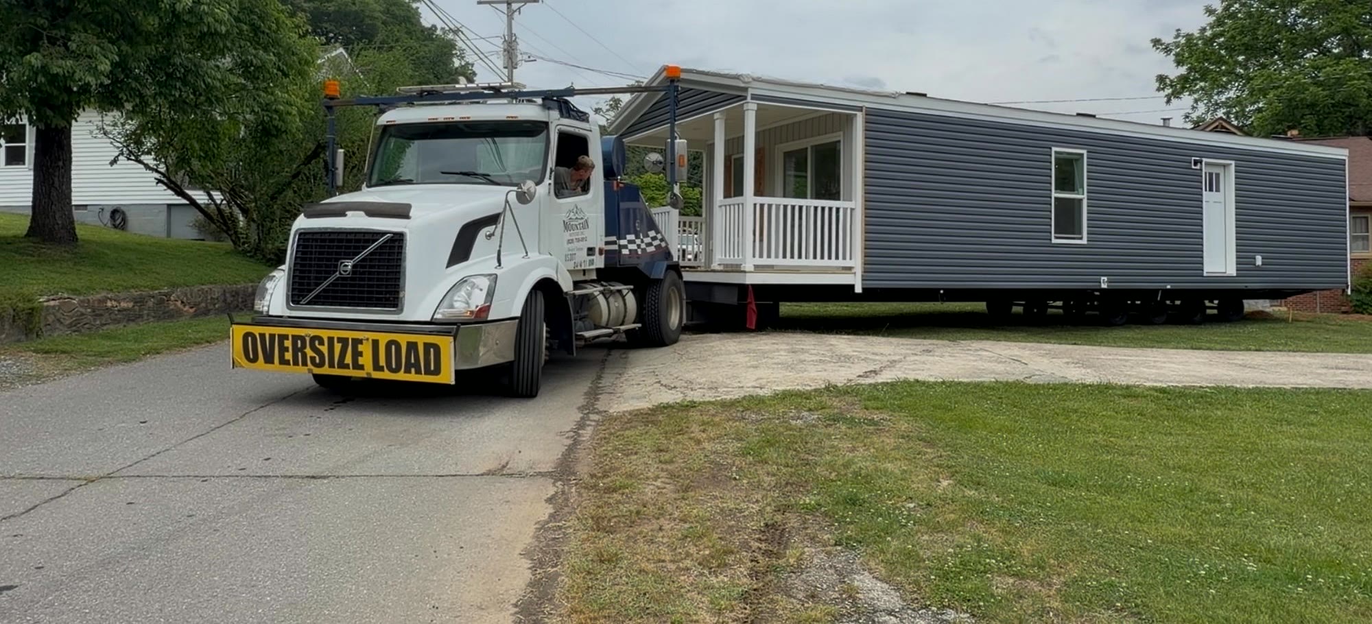 Mountain Movers truck delivering a new home under oversize-load permit